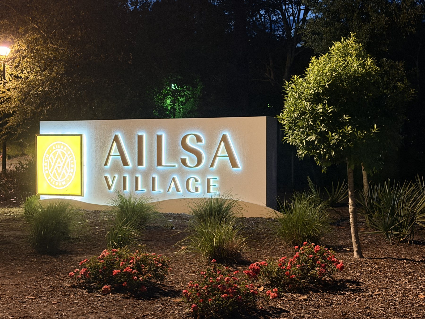 Ailsa Village illuminated monument sign at night