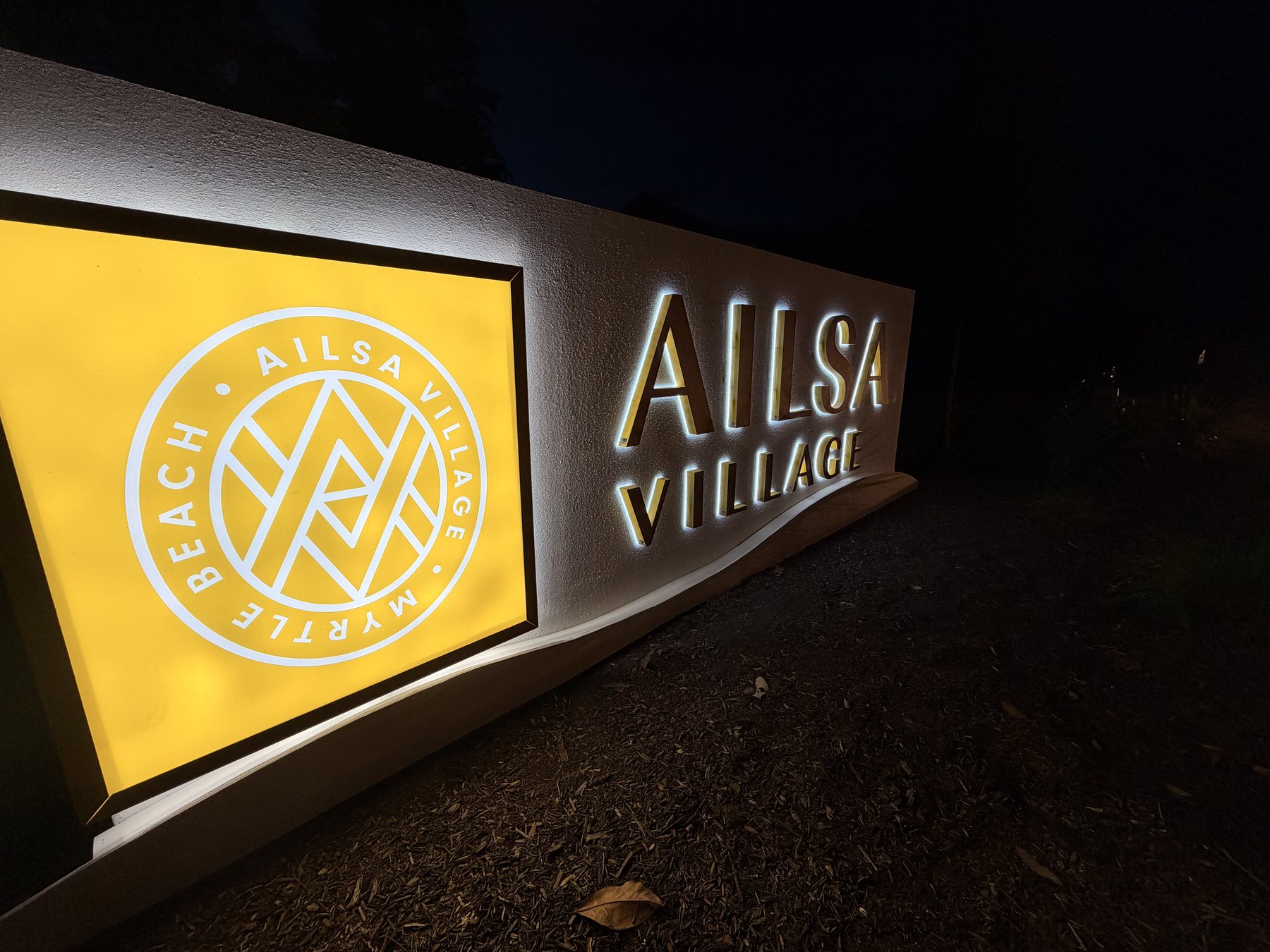 Illuminated logo cabinet detail on the Ailsa Village monument sign