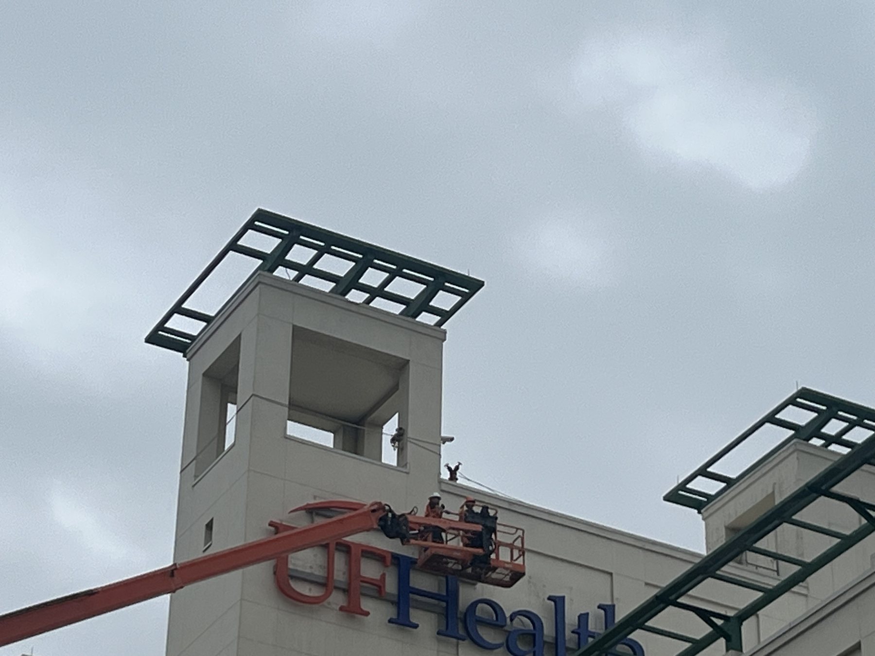 Boom lift installing high-rise channel letters on a commercial building