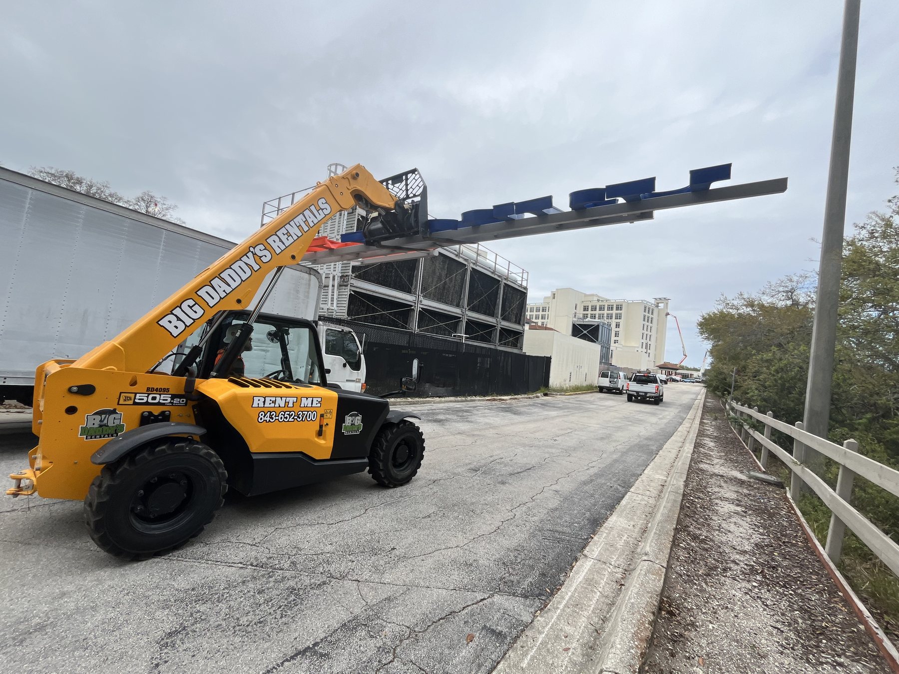 Telehandler placing a large rooftop sign structure