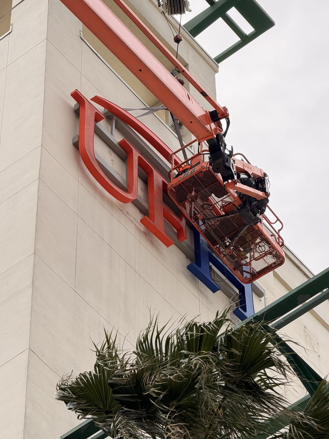 Boom lift installation of exterior channel letters on a commercial storefront